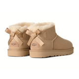 UGG® Classic Ultra Mini Bailey Bow (Women) - Sand